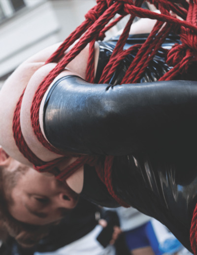 Drummer Mag Man Wearing Rubber Suspended And Bound In Red Rope