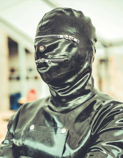 Drummer Mag Pic Of Rubber Clad BDSM Slave In Zippered Hood